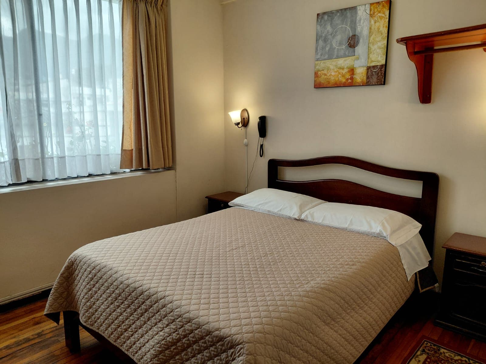 Habitación acogedora con cama doble e iluminación cálida en hostal céntrico de Quito