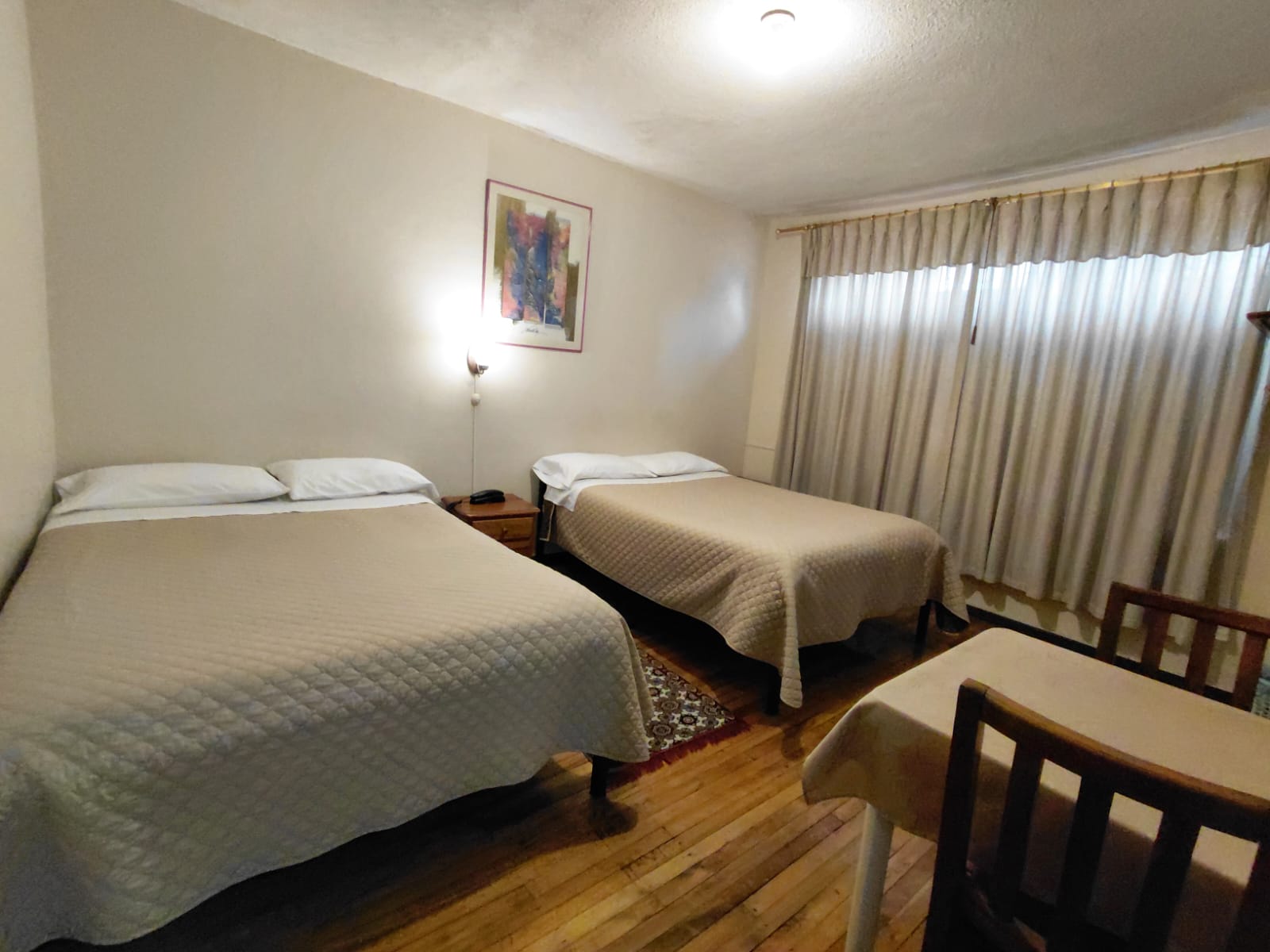 Habitación doble con dos camas y mesa de trabajo ideal para viajeros en Quito
