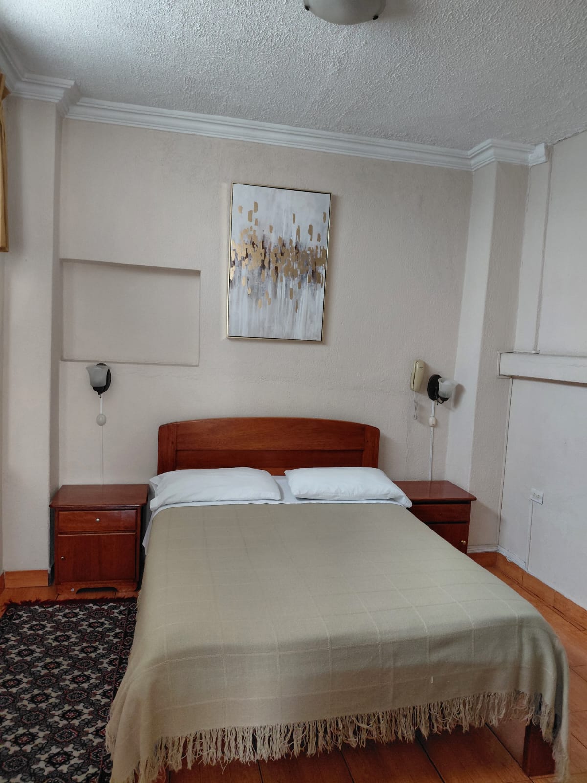 Suite con cama queen y decoración elegante en hostal premium de Quito