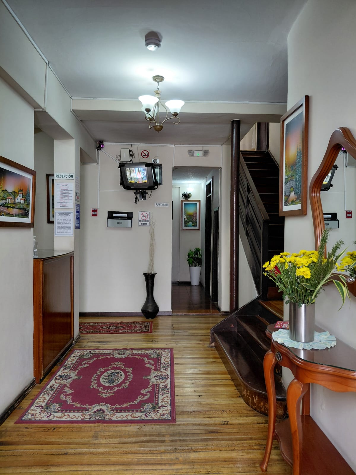 Recepción y lobby acogedor del Hostal Santa María Gracia con decoración clásica