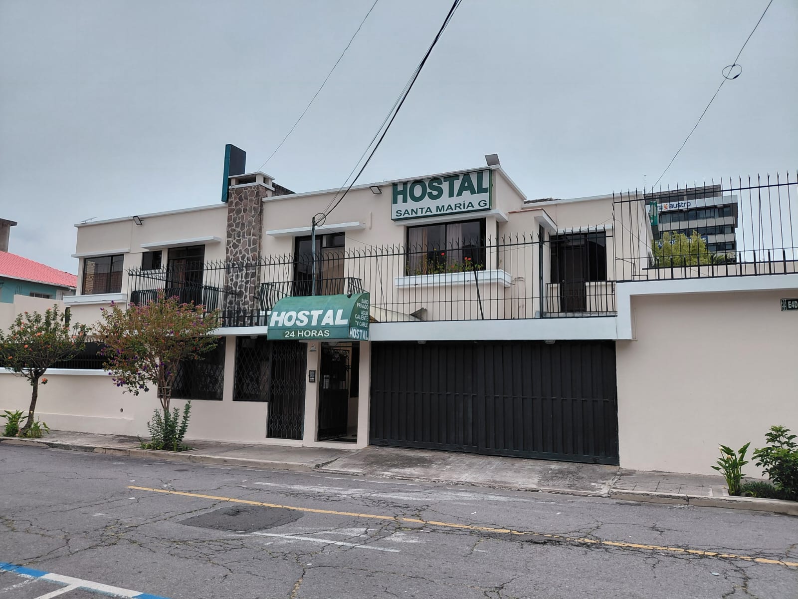 Fachada frontal del Hostal Santa María Gracia en Quito con letrero iluminado