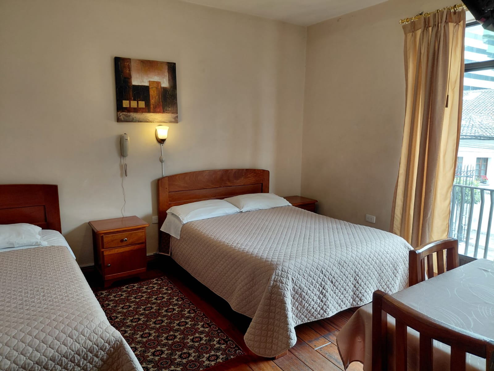 Habitación doble con balcón y vista a la ciudad de Quito en hostal céntrico